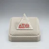 DST pyramid pin in silver-tone metal with clear and crimson rhinestones and red DST letters