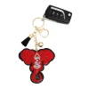 DST elephant keychain with gold-tone elephant head, red and clear rhinestones, and black tassel