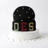 OES beanie in black knit with green, red, and yellow rhinestone OES letters on folded brim