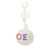 OES keychain with white padded rhinestone circle charm, white tassel, and gold-tone clip